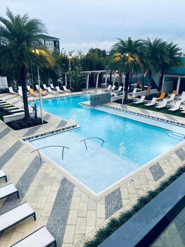 a large swimming pool with lounge chairs and palm trees at **Dream Luxury ** in the high rise downtown Orlando in Orlando