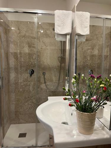 La salle de bains est pourvue d'une douche et d'un lavabo fleuri. dans l'établissement Casa Morganti-, à Sesto San Giovanni