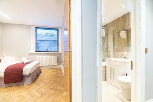 una camera con letto, servizi igienici e lavandino di Stunning Hyde Park Apartments a Londra