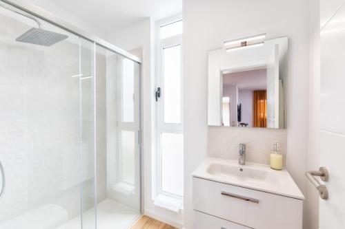 biała łazienka z umywalką i prysznicem w obiekcie Duplex Tendal - Amplio y reformado adosado w mieście Santa Cruz de la Palma