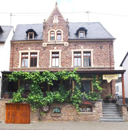 Una casa de ladrillo con muchas plantas. en Weingut Pension Hammes-Krüger, en Ellenz-Poltersdorf