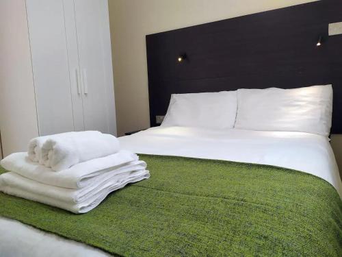 Una cama con toallas blancas y un osito de peluche. en The Beech Flat - Self contained one bedroom flat with parking, en Oxford