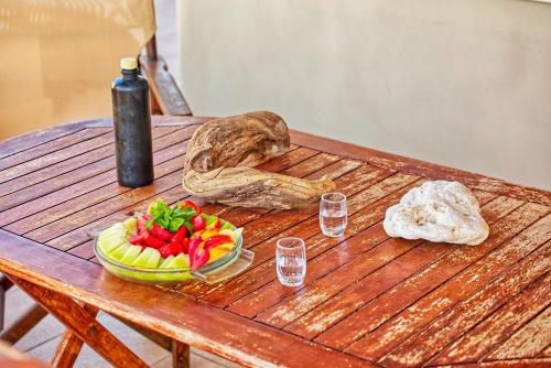 un tavolo in legno con un cesto di frutta e una bottiglia di Ulivo Sea View House a Kokkíni Khánion