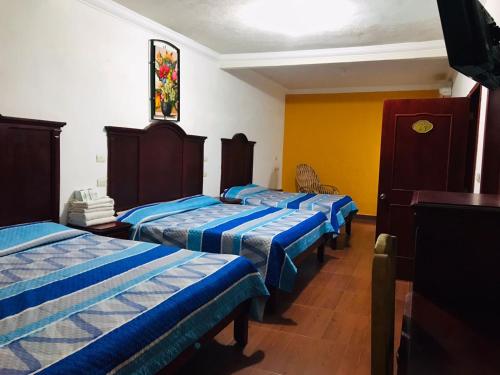 a room with four beds and a stained glass window at Hotel Campo Real Plus Tamasopo in Tamasopo