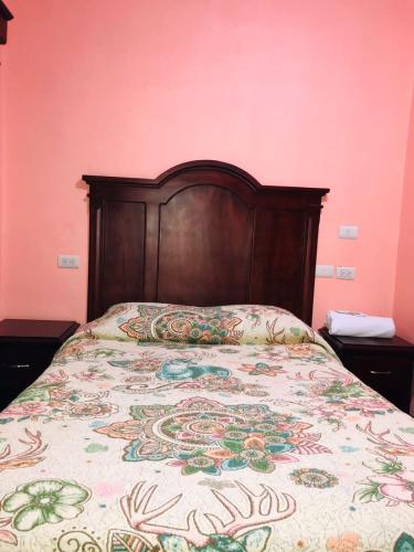 a bed with a wooden headboard in a bedroom at Hotel Campo Real Plus Tamasopo in Tamasopo