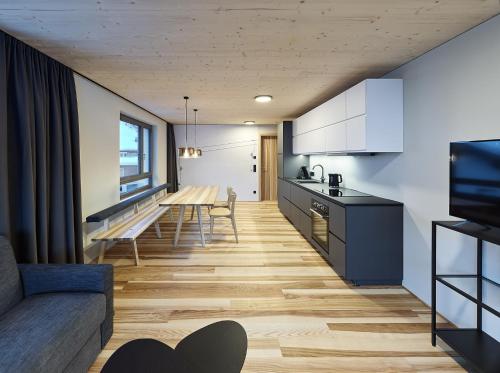 a kitchen and living room with a table and a couch at DER*ADLER Apartments in Schoppernau