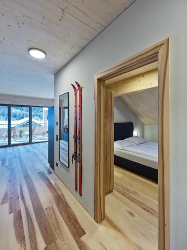 a bedroom with a bed and a door leading to a bedroom at DER*ADLER Apartments in Schoppernau