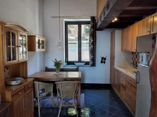 una cucina con tavolo, sedie e finestra di Maison Al Nocino a Stresa