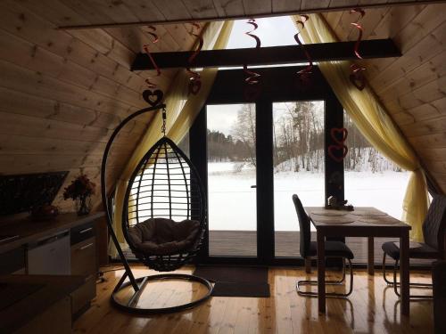 a room with a swing and a table and a window at Aleksandra Viesu Namiņš in Aglona