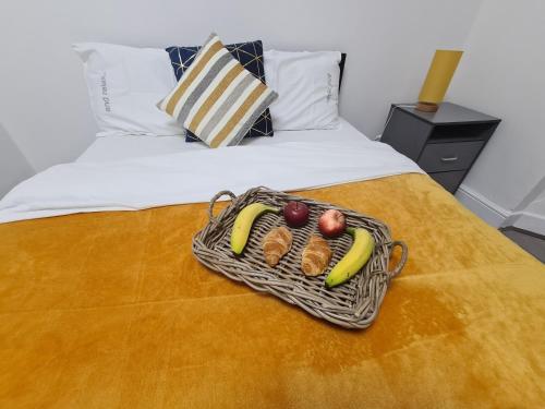a basket of fruit sitting on top of a bed at Property Malak Homz - West Street 2 Bed Premium Apartment in Leicester