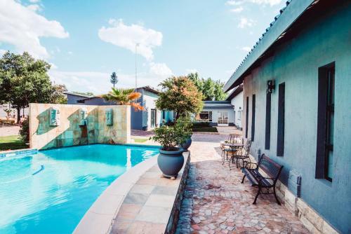 a house with a swimming pool next to a building at Le Grant Guesthhouse in Kroonstad