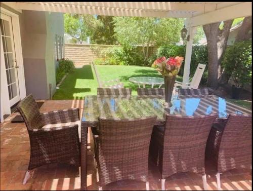 a table with chairs and a vase of flowers on a patio at Valencia CA Stunning 3100 +sqft, 5Bed/5Bath home in Santa Clarita