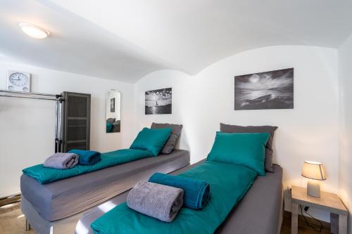 2 camas en una sala de estar con cojines verdes en revLIVING Apartments Eggenburg - Garten - Netflix - Disney Plus - Nespresso, en Eggenburg