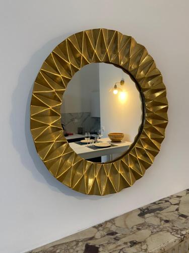a gold mirror on a wall with a table at Résidence Adam à part in Valenciennes