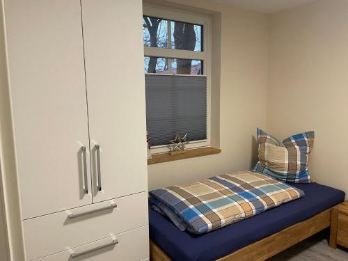 a bedroom with a cabinet and a pillow on a bed at Ferienwohnung Haus Peters "De olle Warkstee" in Elmlohe