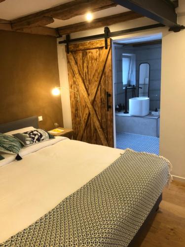 1 dormitorio con cama y puerta corredera de granero en Die Grüne Bettlad Boutique-Hotel, en Bühl