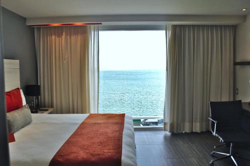 a hotel room with a bed and a large window at Real Inn Cancún in Cancún
