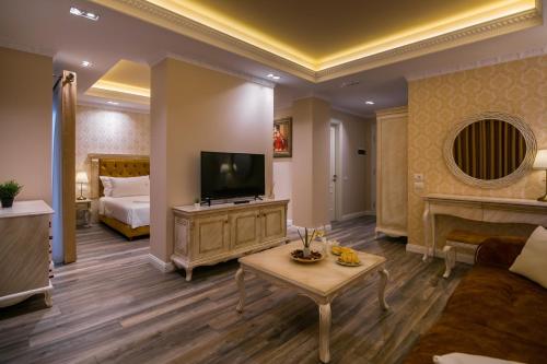 a large living room with a television and a bed at Legacy Boutique Hotel in Korçë