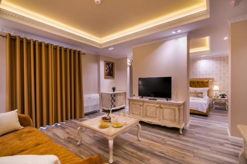 a living room with a couch and a television at Legacy Boutique Hotel in Korçë