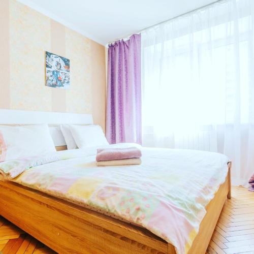 een bed in een kamer met een groot raam bij 1 room 50m2 center of Obolon near River side. Dream Town in Kiev