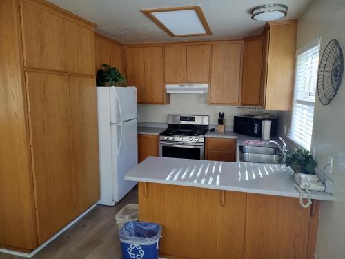 a kitchen with wooden cabinets and a white refrigerator at Yosemite Gatekeeper's Lodge in El Portal