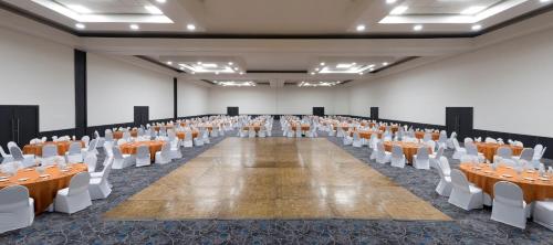 an empty banquet hall with tables and white chairs at Real Inn Tijuana by Camino Real Hoteles in Tijuana
