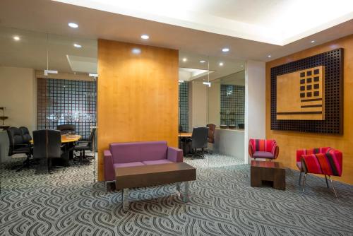 a waiting room with a purple couch and chairs at Real Inn Perinorte in Mexico City