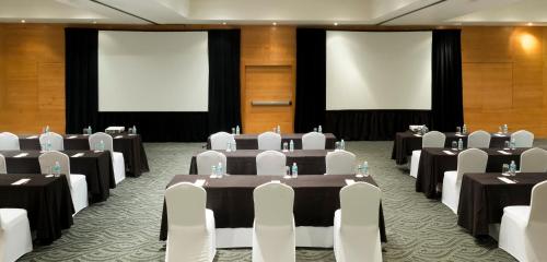 a conference room with tables and chairs and screens at Real Inn Perinorte in Mexico City