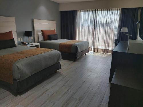 a hotel room with two beds and a large window at Real Inn Perinorte in Mexico City