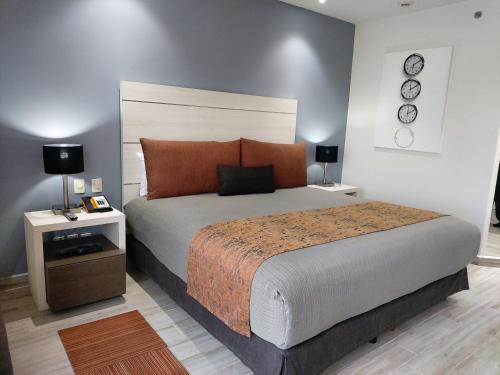 a bedroom with a large bed and two night stands at Real Inn Perinorte in Mexico City