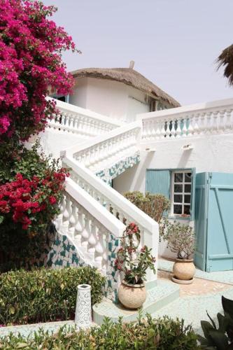 a white staircase with flowers in front of a house at West AFRICAN BEACH in Sali Nianiaral