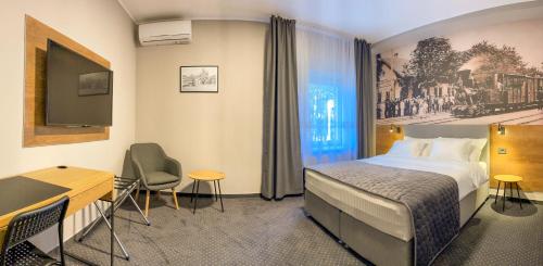 a hotel room with a bed and a desk at Industrial Belišće in Belišće