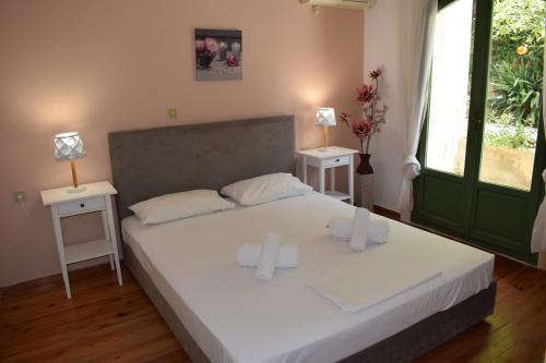 a bedroom with a bed with two tables and two lamps at Bellevue Apartments in Sitia