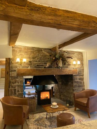 a living room with a fireplace and a stone wall at Three Cocks Hotel in Brecon