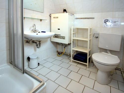 La salle de bains est pourvue de toilettes, d'un lavabo et d'une douche. dans l'établissement House Krischan, Dornumersiel, à Dornumersiel