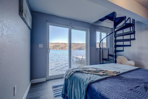 um quarto com uma cama e vista para a água em Modern Winnipesaukee Lake Front Retreat (Venice) em Alton