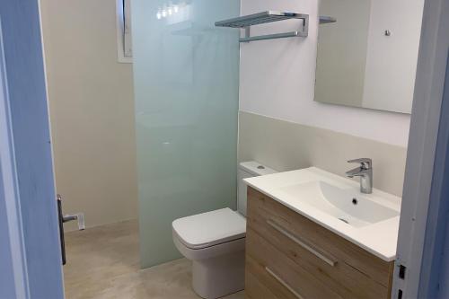 La salle de bains est pourvue d'un lavabo blanc et de toilettes. dans l'établissement Casa rural Can Pep de Sa Barda - Entre viñedos - Formentera Natural, à Sant Francesc Xavier