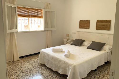 1 dormitorio con 1 cama blanca y ventana en Casa rural Can Pep de Sa Barda - Entre viñedos - Formentera Natural, en Sant Francesc Xavier