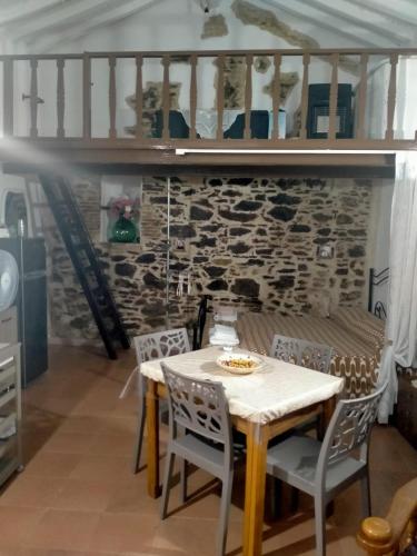 a table and chairs in a room with a stone wall at La lammia di Pisticci in Pisticci