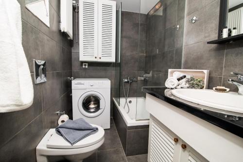 een badkamer met een wasmachine en een wastafel bij Nonna Irene in Rethimnon