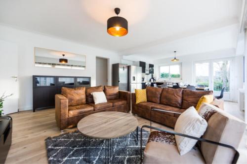 un salon avec des canapés et une table dans l'établissement VILLA CITY GARDEN - Maison Spacieuse et Jardin - Proche Centre ville, à Cholet