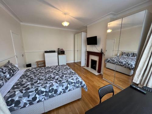 a bedroom with a bed and a fireplace at Gladstone Lodge in London