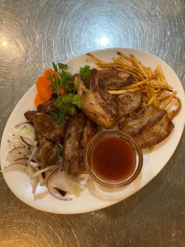a plate of food with meat and french fries at Hotel Dream in Stara Zagora
