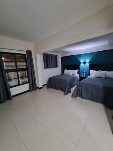 a bedroom with two beds and a blue wall at EMS Hoteles Centro Histórico in Veracruz