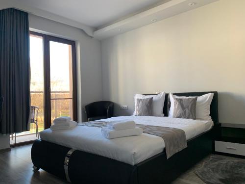 um quarto com uma cama grande e toalhas em Vivian Apartaments em Sandanski