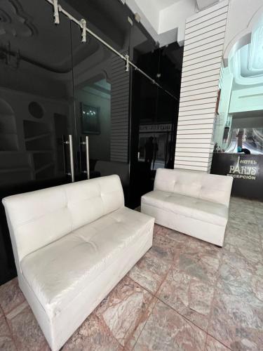 two white leather couches sitting in a room at Hotel Paris in San Juan de los Lagos