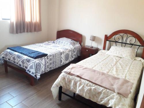 1 dormitorio con 2 camas y 1 mesa con ventana en Hermoso apartamento de estreno en Cajamarca, en Cajamarca