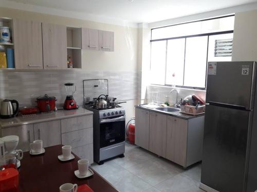 a kitchen with a refrigerator and a stove top oven at Hermoso apartamento de estreno en Cajamarca in Cajamarca