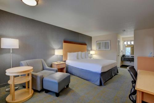 a hotel room with a bed and a chair at Best Western Horizon Inn in Medford