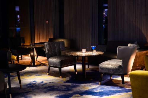 a group of tables and chairs in a room at Best Western Plus Hotel & Restaurant Les Humanistes Colmar Nord in Sélestat